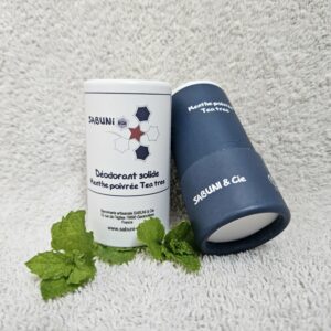 Tube du déodorant (menthe poivrée et tea tree) de Sabuni & Cie, posé sur une serviette, le dessous du tube en carton est visible.